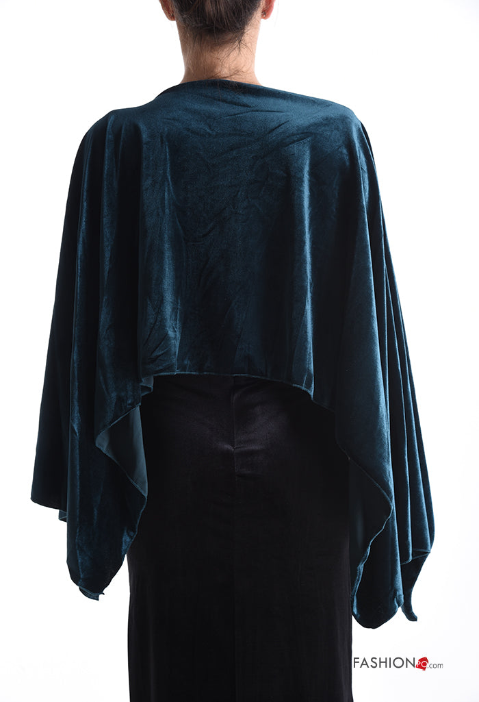 Κάπα βελούδινη σε βαθύ πράσινο,  φορεμένη ως μπλούζα. Έχει συνδυαστεί με φούστα pencil στο ίδιο ύφασμα. Το μοντέλο έχει γυρισμένη πλάτη και πιασμένα μαλλιά.