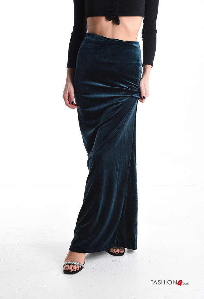 Μακριά βελούδινη pencil φούστα σε βαθύ πράσινο χρώμα. Έχει συνδυαστεί με crop μαύρη μακρυμάνικη μπλούζα και μαύρα σανδάλια με ασημί λεπτομέρειες.