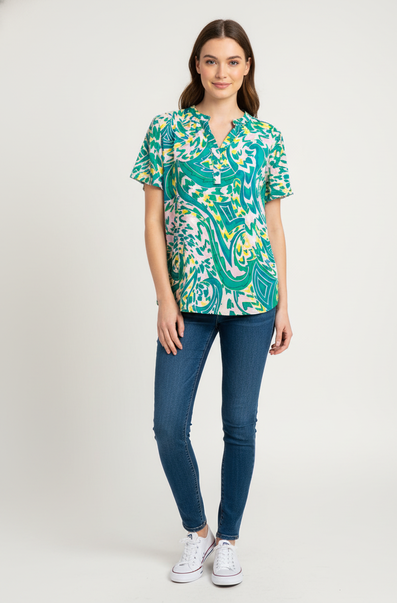 Εμπριμέ μπλούζα με λαχούρια σε πράσινες αποχρώσεις. Έχει κοντά μανίκια και γιακά μάο. 
Το μοντέλο την έχει συνδυάσει με τζιν παντελόνι και άσπρα sneakers