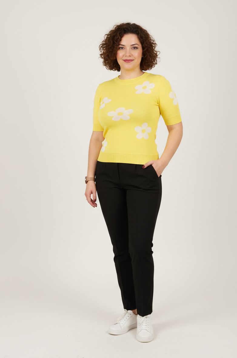 Εφαρμοστό κίτρινο πλεκτό με μαργαρίτες. Κοντομάνικο. Συνδυασμένο με μαύρο παντελόνι και λευκά sneakers.