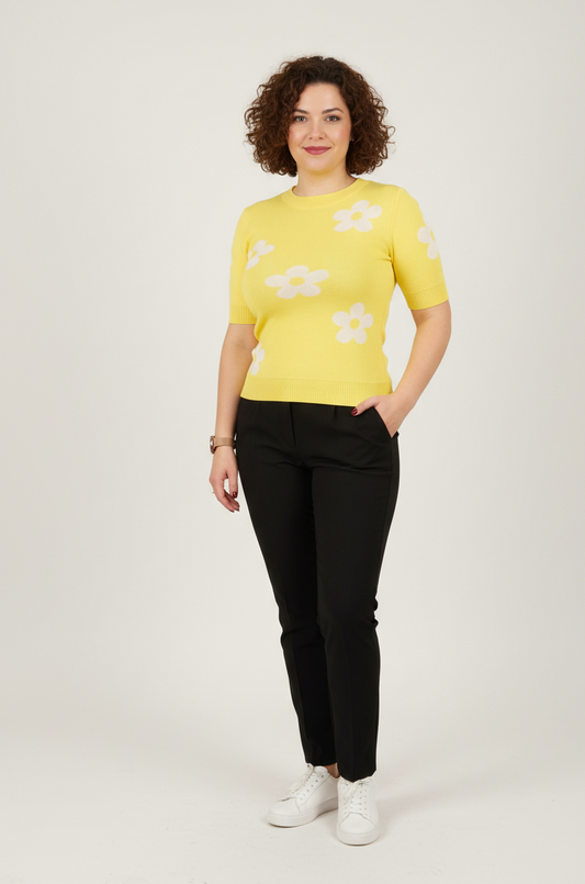 Εφαρμοστό κίτρινο πλεκτό με μαργαρίτες. Κοντομάνικο. Συνδυασμένο με μαύρο παντελόνι και λευκά sneakers.