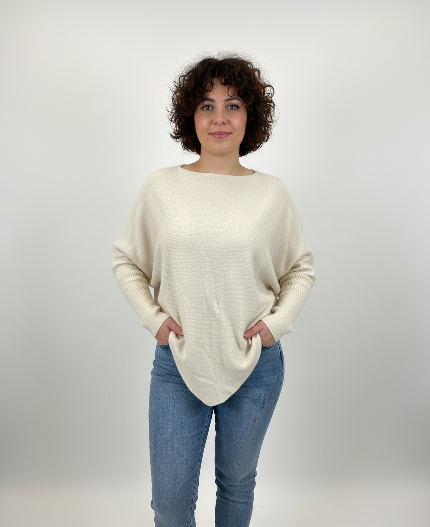 Εκρού πλεκτό με ιδιαίτερο λοξό κόψιμο. Τα μανίκια του είναι εφαρμοστά από τον αγκώνα και κάτω