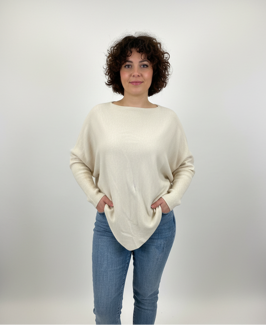 Εκρού πλεκτό με ιδιαίτερο λοξό κόψιμο. Τα μανίκια του είναι εφαρμοστά από τον αγκώνα και κάτω