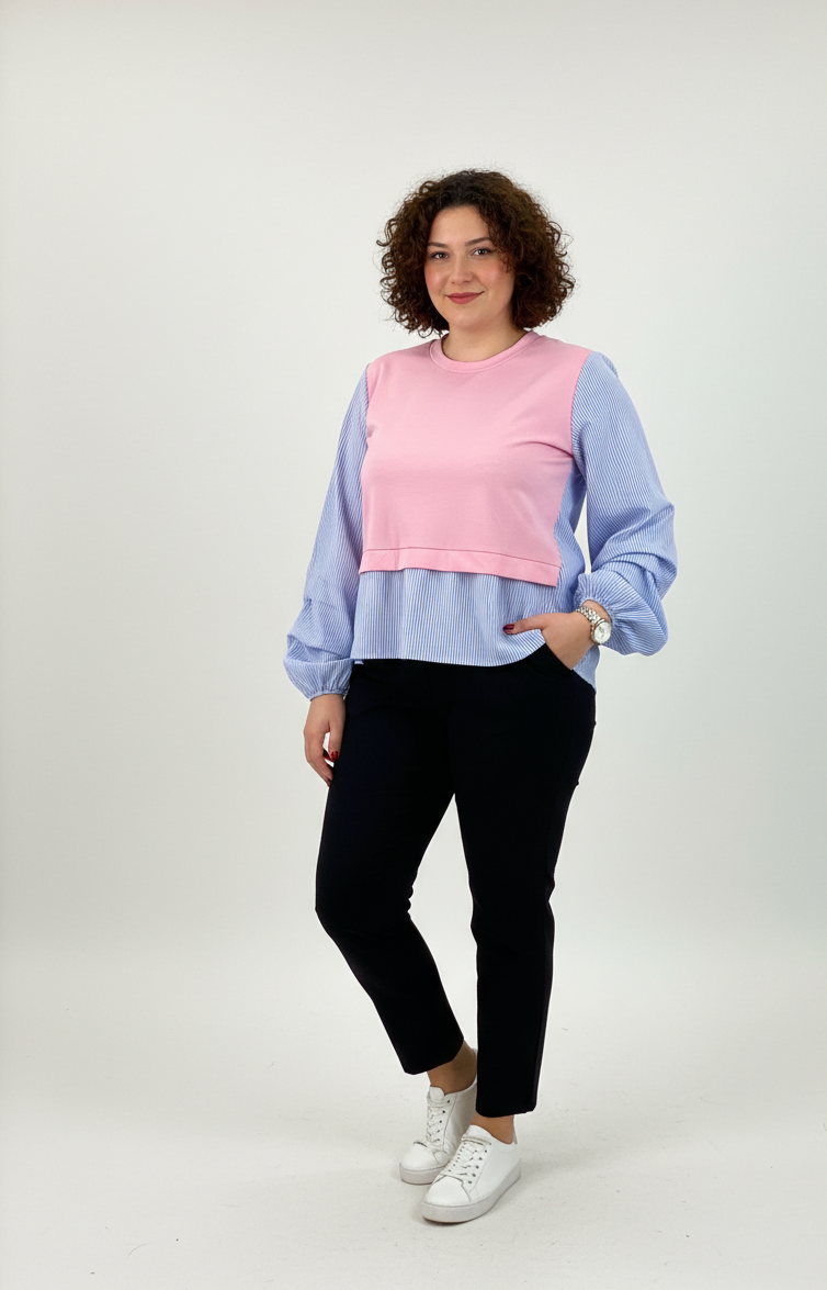 Μπλούζα από ποπλίνα ριγέ γαλάζια σαν πουκάμισο, με λεπτομέρεια από ροζ φούτερ στο μπροστινό μέρος. Μακριά μανίκια. Συνδυασμένη με μαύρο γυναικείο παντελόνι και λευκά sneakers.