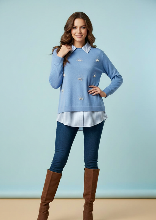 Πουλόβερ γαλάζιο με λεπτομέρειες πουκαμίσου, πέρλες και μικρά στρασάκια. Είναι συνδυασμένο με μπλε τζιν παντελόνι και ψηλές καφέ μπότες